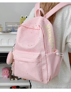 Detail of pink backpack with color dots, side XBK BAG lettering and mini round coin pouch