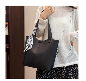 Detail of black pebbled leather tote with floral silk scarf on shoulder strap