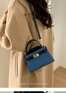 Close-up of denim and leather shoulder bag with gold clasp shown on model