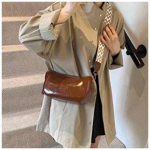 Detail of vintage brown crossbody bag with colorful woven geometric wide strap