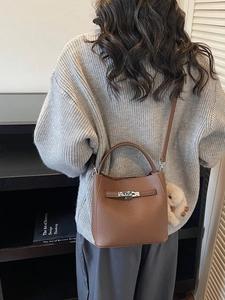 Borsa a secchiello minimalista in pelle marrone con chiusura argento e ciondolo peluche
