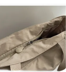 Detail der Tragetasche mit Reißverschluss und weichem Logo-Anhänger im Fokus