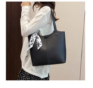 Detail of black lychee textured tote bag with floral silk scarf and vertical stitching