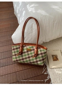 Détail du sac cabas à carreaux verts montrant le nœud de la bandoulière et le logo doré