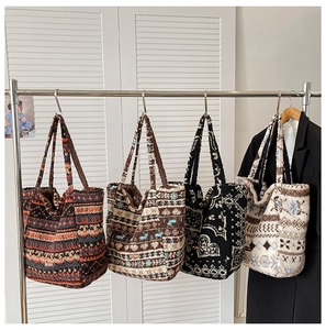 Detail of four ethnic style faux shearling tote bags with diverse patterns on hangers