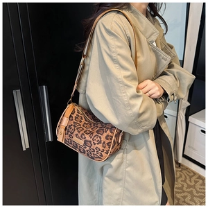 Detail of leopard print pillow bag with metal logo and adjustable wide textile strap