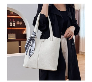 Chic beige lychee leather tote bag with floral scarf shown in a stylish room setting