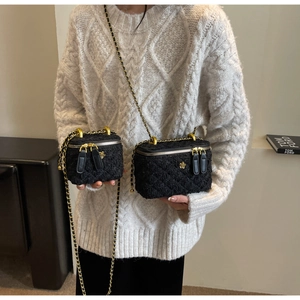 Detailed view of tweed crossbody box bag with gold chain strap and camellia charm decoration