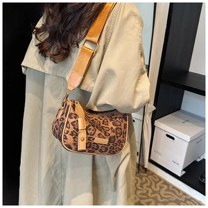 Detail view of leopard print crossbody bag with wide adjustable shoulder strap on model