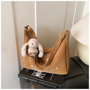 Detalle de bolso hobo de cuero PU marrón con estampado de gato y colgante de conejo