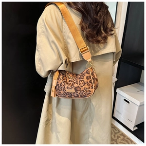 Detail of wide nylon strap and leopard print on a vintage crossbody pillow bag