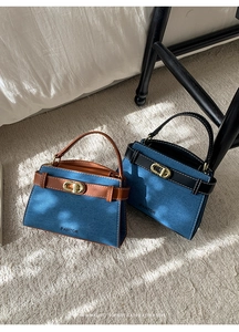 Detailed view of denim handbags featuring leather straps and oval metal twist locks