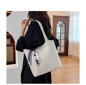 Close-up of ivory tote bag with pebble leather texture and floral silk scarf detail