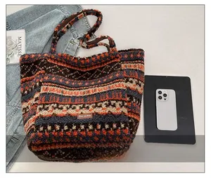 Detail of colorful bohemian striped wool tote bag with leather logo patch and soft texture