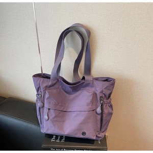 Détail du sac cabas en nylon violet imperméable avec poches à cordon et fermeture éclair