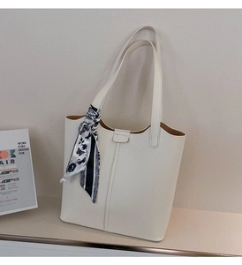 Detail of off-white tote bag with litchi texture and decorative butterfly print scarf