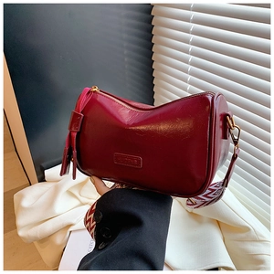 Detail of burgundy vintage pillow bag with HUIZENG logo and geometric patterned strap