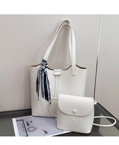 Close-up of white lychee leather tote bag with silk scarf detail and small crossbody bag