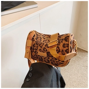 Detail of leopard print cylinder crossbody bag with brown strap and leather brand patch