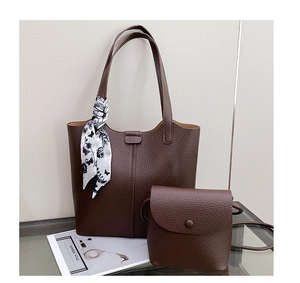 Detail of dark brown lychee leather tote bag set with floral silk scarf accessory