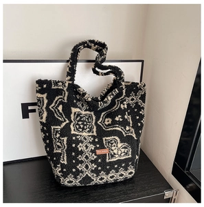 Detail of retro lamb wool tote bag with black and white texture and brown leather label