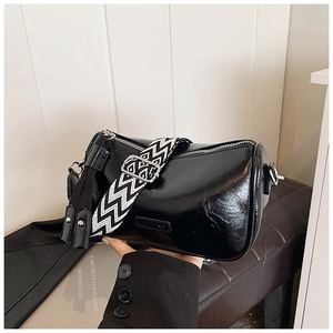 Detail of black cylindrical bag featuring a woven strap and HUIZENG side logo