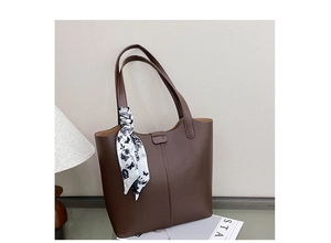 Detail of brown litchi pattern leather tote bag with floral scarf on handle