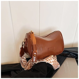 Detail of vintage brown oil wax leather bag with geometric pattern woven shoulder strap