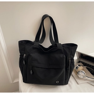 Vue détaillée du grand sac cabas en nylon noir avec poches et accessoires de bureau