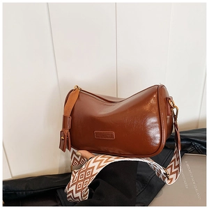 Detail of vintage brown pillow bag showing HUIZENG logo and geometric patterned strap