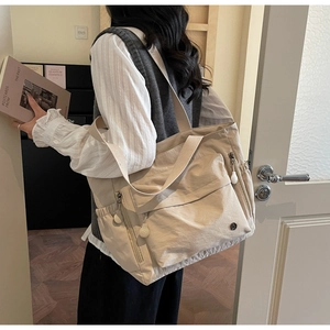 Gros plan détaillé d'un grand sac cabas beige en nylon avec poches extérieures zippées