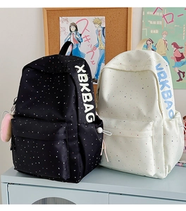 Detail view of large school backpacks in black and cream with polka dot patterns