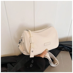 Detail of a creamy Boston bag with glossy finish and textured wide shoulder strap