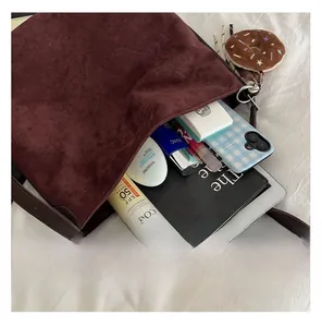 Spacious interior of burgundy suede tote bag showing capacity for daily essentials
