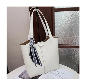 Close-up of white lychee leather tote bag with silk scarf detail and caramel lining