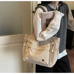 Détail du grand sac cabas beige en nylon avec poches fonctionnelles et bandoulière
