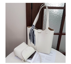 Close-up of creamy white lychee grain leather tote bag set with striped silk scarf detail