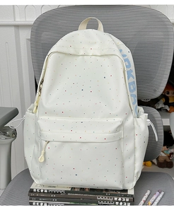 Detail of off-white school backpack with colorful patterns and side drawstring pocket