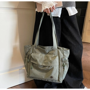 Détail macro du sac fourre-tout en nylon avec poche à rabat et cordon de serrage latéral