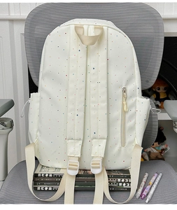 Detail view of the backpack back featuring thick shoulder straps and a vertical side pocket