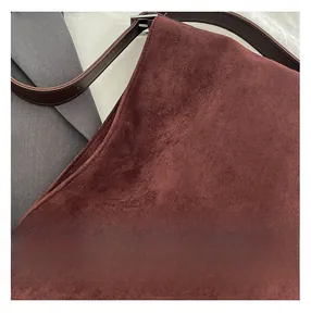 Detailed macro view of tan suede leather texture and stitching on a large tote bag