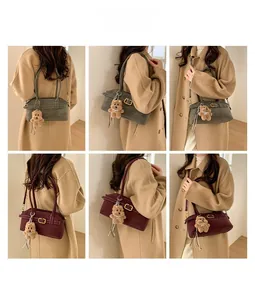 Detail of vintage style leather shoulder bag with gold buckle and cute plush bear charm