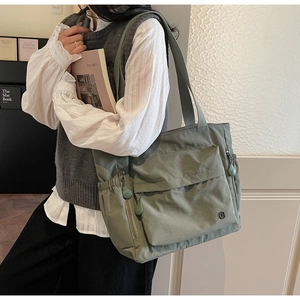 Detail der olivgrünen Nylon-Einkaufstasche mit Multi-Pocket-Design und breitem Schultergurt