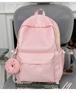 Detailed shot of pink polka dot backpack with a cute 3D donut plush keychain charm