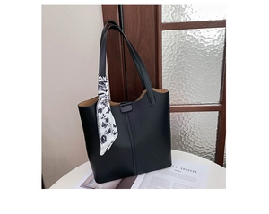 Close-up of black lychee-textured tote bag featuring a floral scarf handle and brown interior