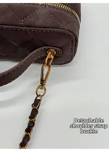 Macro detail of dark coffee quilted bag featuring gold metal hook and chain strap