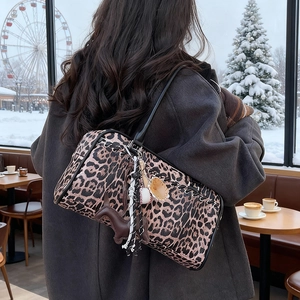 Bolso tote grande con estampado de leopardo llevado por modelo en un café invernal