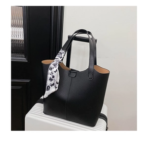 Close-up of black lychee grain leather tote bag with elegant butterfly print silk scarf detail