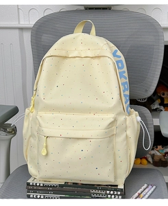 Detail of light yellow backpack with star patterns and YBK BAG side logo print