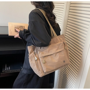 Vue détaillée du grand sac cabas kaki avec poches latérales à cordon et logo discret